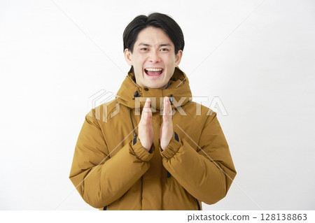 Man wearing down jacket clapping white background 128138863
