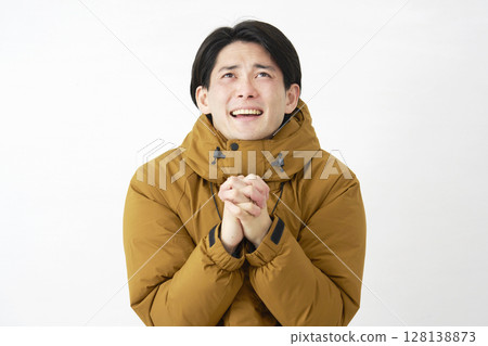 Man wearing down jacket pleading white background 128138873