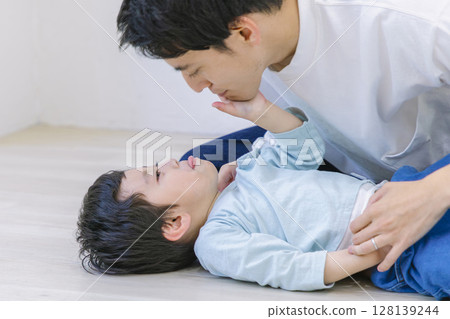 父親在家裡的客廳和兒子玩耍 父親在家裡的客廳和兒子玩耍 128139244