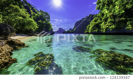 Stunning Tropical Beach Scene with Crystal Clear Water and Lush Green Landscape Stunning Tropical Beach Scene with Crystal Clear Water and Lush Green Landscape 128139387