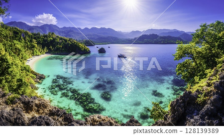 Serene Tropical Beach with Clear Water and Lush Green Mountains Under Sunlight Serene Tropical Beach with Clear Water and Lush Green Mountains Under Sunlight 128139389