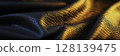 Shimmering Fabric Waves with Golden and Blue Light Reflections for Artistic Backgrounds 128139475