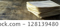 Stack of Blank Paper Sheets on Rustic Wooden Table with Natural Light 128139480