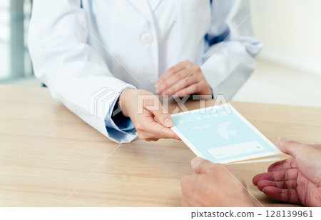 A female pharmacist handing over a prescription 128139961