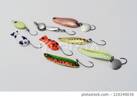 在白色背景上拍攝的一組色彩繽紛的魚餌、勺子和其他人工魚餌 128140038