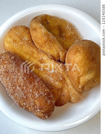 Golden and crispy kkwabaegi, Korean twisted donuts with a soft, fluffy interior, coated in sugar and cinnamon. A sweet and chewy treat perfect for snacking or dessert. 128140386