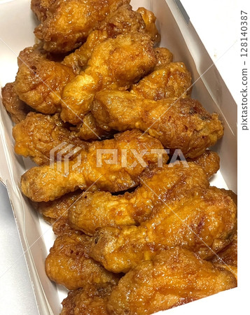 Crispy Korean fried chicken, perfectly glazed with a sweet and spicy sauce. Ideal for food photography and menus, showcasing the irresistible crunch and flavor of this beloved dish. 128140387