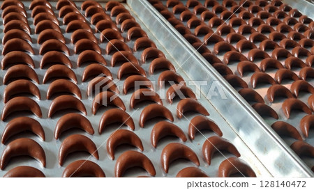Soft and crumbly putri salju coklat cookies coated in powdered sugar, offering a rich chocolate flavor with a melt-in-your-mouth texture. A delightful treat for any occasion. 128140472