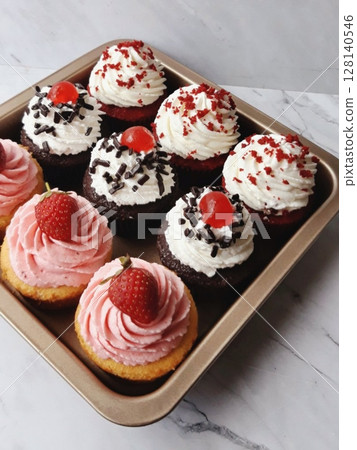 A delightful cupcake topped with rich frosting and decorative sprinkles. Perfect for dessert photography, showcasing the charm and sweetness of baked goods, ideal for parties and celebrations. A delightful cupcake topped with rich frosting and decorative sprinkles. Perfect for dessert photography, showcasing the charm and sweetness of baked goods, ideal for parties and celebrations. 128140546