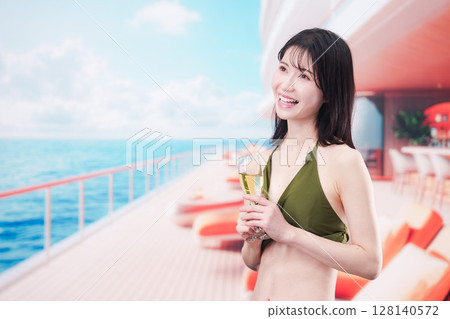 Young woman wearing swimsuit drinking sparkling wine on cruise ship 128140572