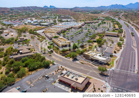Shopping center commercial district in Fountain Hills, Arizona business area features multiple buildings, parking lots, office buildings along East Shea Boulevard in this suburban commercial zone. 128140693