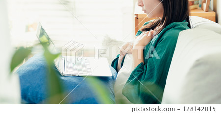 Young woman using a computer in the living room 128142015