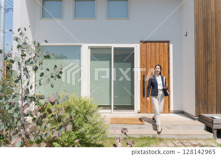 A woman in a suit exiting the entrance 128142965