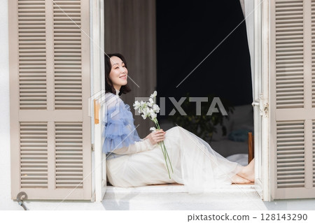 一個女人坐在窗邊 128143290