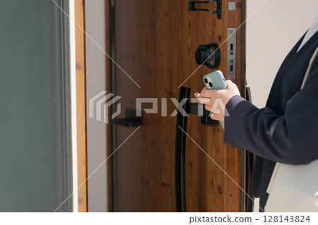 一名穿西裝的女子正在鎖門 128143824