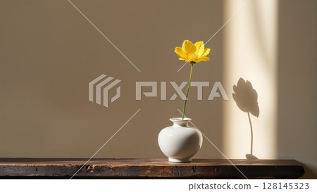 一朵黃花和一個白色花瓶，透過陰影描繪出一幅寧靜的春日景象 128145323