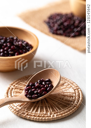 Raw Azuki beans or red mung beans in wooden spoon and bowl on white background, Food ingredient Raw Azuki beans or red mung beans in wooden spoon and bowl on white background, Food ingredient 128145642