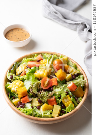 Colorful vegetable salad in a rustic wooden bowl with Japanese sesame dressing Colorful vegetable salad in a rustic wooden bowl with Japanese sesame dressing 128145687