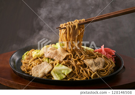 Fried noodles served on a hot plate 128146508