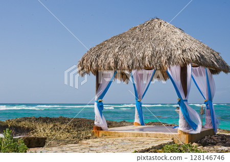 Gazebo by the sea, surrounded by beautiful turquoise waters, decorated for a wedding ceremony 128146746