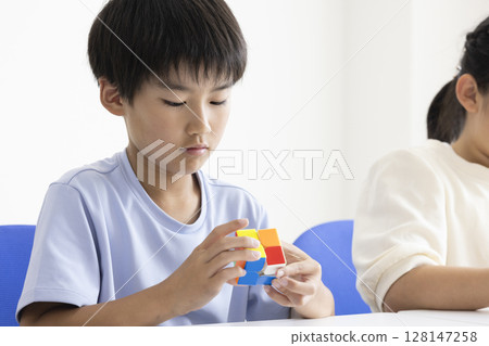 Elementary school student playing Rubik's Cube 128147258