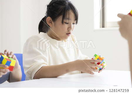 Elementary school student playing Rubik's Cube 128147259