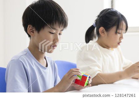 Elementary school student playing Rubik's Cube 128147261