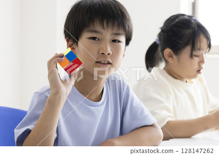 Elementary school student playing Rubik's Cube Elementary school student playing Rubik's Cube 128147262