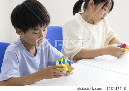 Elementary school student playing Rubik's Cube 128147348