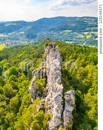 Discover the stunning sandstone formations of Suche skaly in Bohemian Paradise, Czechia. Surrounded by lush greenery, these dry rocks offer breathtaking views of the landscape and surrounding hills. 128148371
