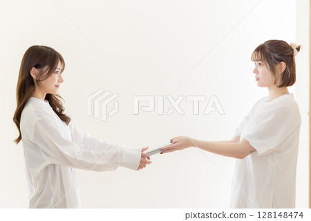 Woman handing over a book 128148474