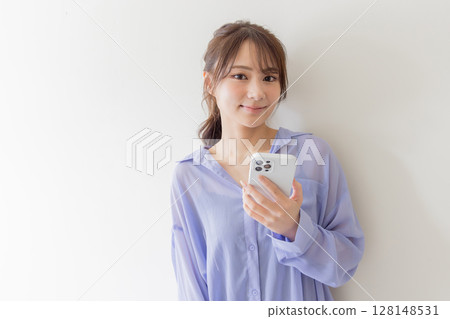A cute woman searching on a smartphone A cute woman searching on a smartphone 128148531