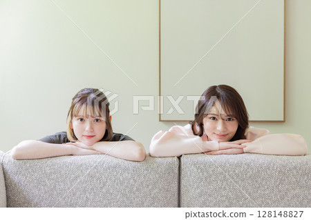 Room share, share house, woman peeking out from the sofa 128148827