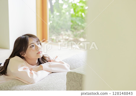 Cute woman leaning on the sofa Cute woman leaning on the sofa 128148843