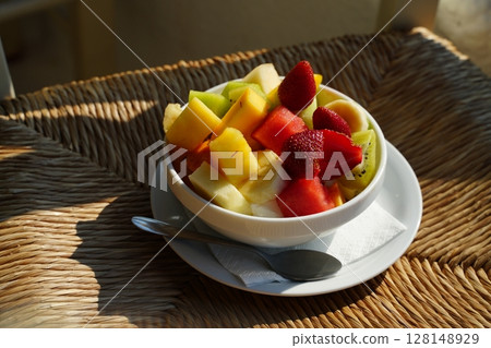 Colorful Fresh Fruit Salad in White Bowl with Spoon 128148929