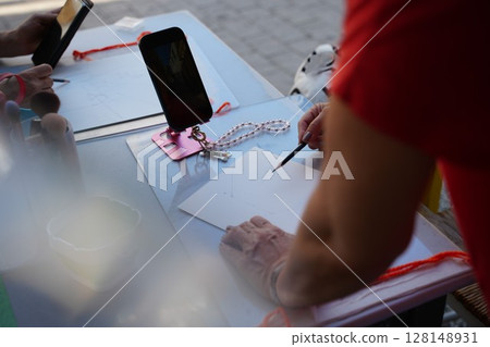Artist Drawing at Outdoor Table with Smartphone References 128148931