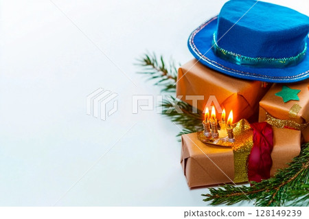 Glowing candles beside a hat and wrapped gifts create a cozy atmosphere for celebrations Glowing candles beside a hat and wrapped gifts create a cozy atmosphere for celebrations 128149239