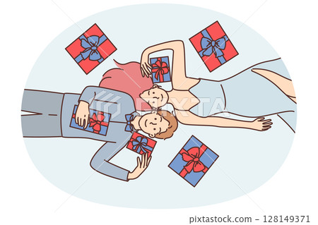 Satisfied man and woman lie on floor among Christmas gift boxes and enjoy festive mood Satisfied man and woman lie on floor among Christmas gift boxes and enjoy festive mood 128149371