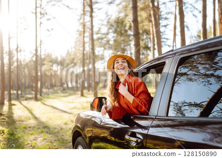 Young woman leaning out of the car window enjoying nature. Road trips summer holidays. 128150890