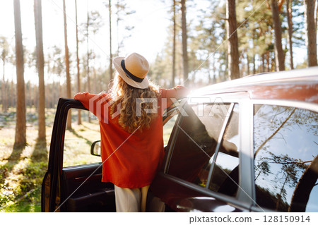 Stopping during a car trip. Young woman enjoying nature. Journey by car. Lifestyle, travel, tourism Stopping during a car trip. Young woman enjoying nature. Journey by car. Lifestyle, travel, tourism 128150914