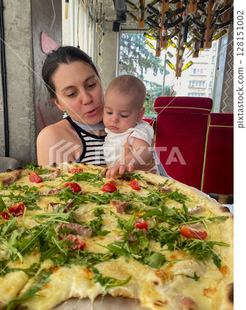 Mother and Baby Enjoying Pizza at a Restaurant Mother and Baby Enjoying Pizza at a Restaurant 128151002