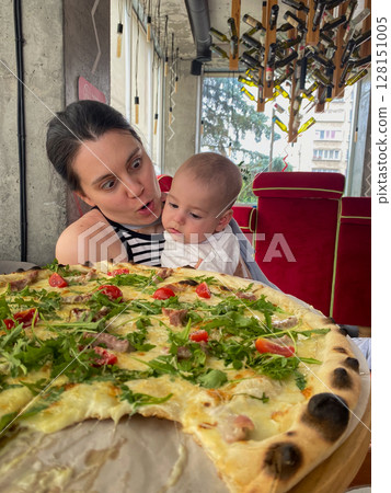 Mother and Baby Enjoying Pizza at a Restaurant Mother and Baby Enjoying Pizza at a Restaurant 128151005