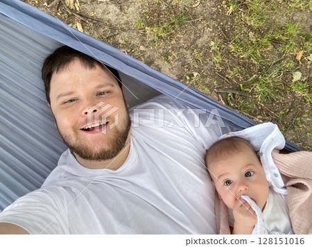Father and Baby Relaxing in Hammock Outdoors Father and Baby Relaxing in Hammock Outdoors 128151016