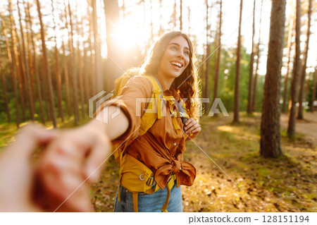 Traveling together. Happy woman holds the boyfriend's hand and walking on the forest. Vacation Traveling together. Happy woman holds the boyfriend's hand and walking on the forest. Vacation 128151194