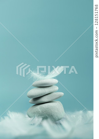 Balanced Stones and white feather on blue background, Calm and stable mindset, inner peace and emotional steadiness , Vertical image Balanced Stones and white feather on blue background, Calm and stable mindset, inner peace and emotional steadiness , Vertical image 128151768
