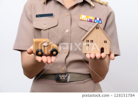 Young Thai Asian Teacher in the uniform is holding the wooden car and wooden house 128151784