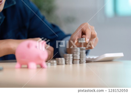 Counting Coins for Savings. Close-up of hands stacking coins with piggy bank. Counting Coins for Savings. Close-up of hands stacking coins with piggy bank. 128152050