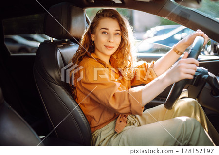Stylish woman driving car. Traveler is the driver. Automobile travel. Sharing car. Lifestyle concept Stylish woman driving car. Traveler is the driver. Automobile travel. Sharing car. Lifestyle concept 128152197
