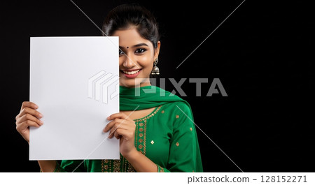 Girl with blank empty paper. Indian lady is advertising something. The background is black 128152271