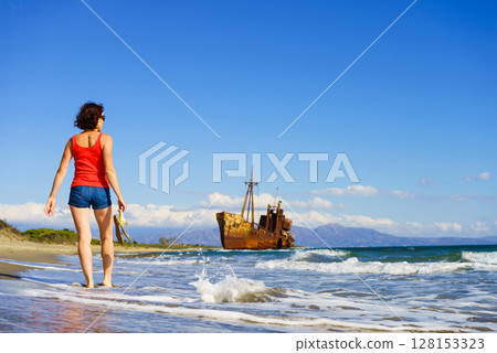 Tourist woman on beach enjoying vacation 128153323